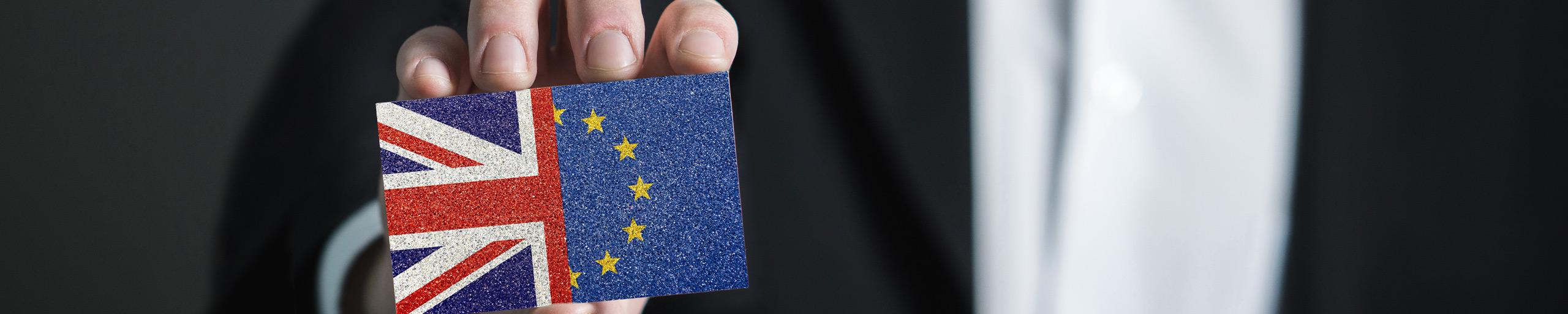 Man houdt kaartje omhoog met daarop vlag van EU en het Verenigd Koningrijk, Brexit