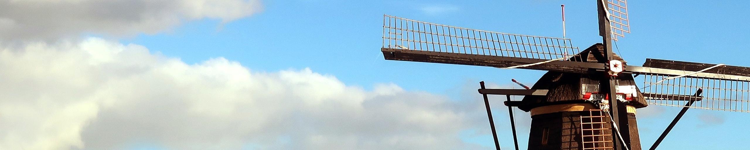 Afbeelding van een windmolen tegen een achtergrond van wolken en blauwe lucht